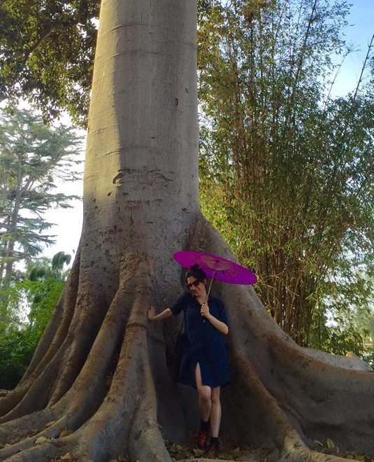 Actress Erika Ward under a tree in Balboa Park with a parasol