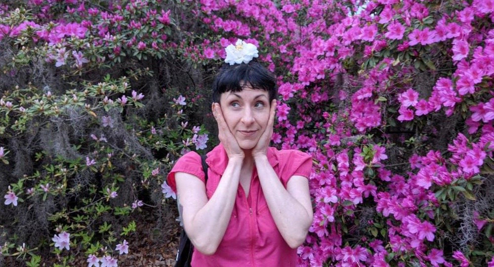 Actress Erika Ward surrounded by pink flowers